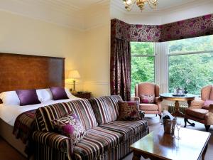 a living room filled with furniture and a large window at Macdonald Norwood Hall Hotel in Aberdeen