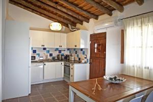 a kitchen with white appliances and a wooden table at Herdade dos Mestres in Terena