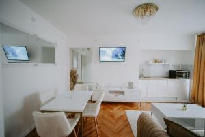 a living room with a table and chairs and a kitchen at Gold Luxury Apartment in Bosanska Gradiška