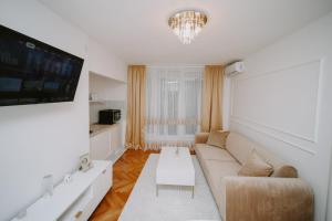a living room with a couch and a tv at Gold Luxury Apartment in Bosanska Gradiška