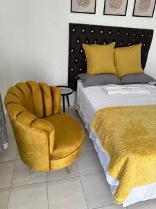 a bedroom with a yellow chair next to a bed at Township Lodge -Seshego in Polokwane