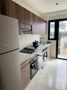 a kitchen with a stove and a sink and a refrigerator at 35 Appartement ensoleillé calme et NEUF in Casablanca +35 photos