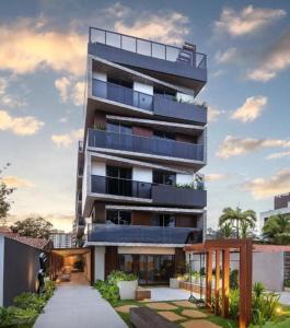 an apartment building with a walkway in front of it at Way Bossa Praia do Bessa in João Pessoa