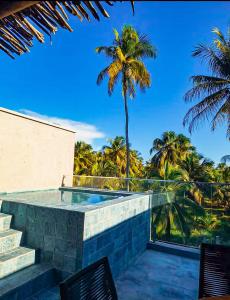 - une piscine avec 2 chaises et un palmier dans l'établissement Casa com piscina - Milagres - Praia e Capela, à São Miguel dos Milagres