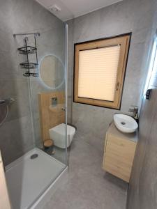 a bathroom with a shower and a toilet and a sink at Domek z bali Zakopane in Zakopane