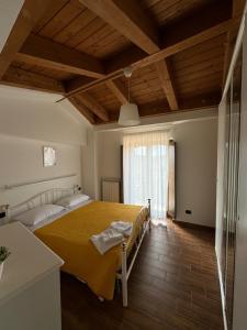 a bedroom with a large bed with a yellow blanket at La Pietra Gialla in Pietrapertosa