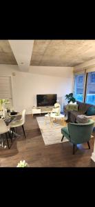 un salon avec un canapé, des chaises et une télévision dans l'établissement Condo 2 chambres avec parking privé - Griffintown, à Montréal