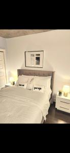 une chambre avec un grand lit avec des draps et des oreillers blancs dans l'établissement Condo 2 chambres avec parking privé - Griffintown, à Montréal 10 autres photos