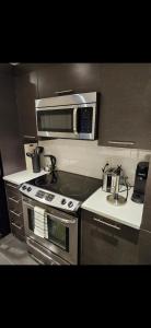 une cuisine avec une cuisinière et un micro-ondes dans l'établissement Condo 2 chambres avec parking privé - Griffintown, à Montréal