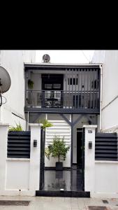 un edificio con balcone e porta con una pianta di CYRUS Hôtel -Housse cœur de ville a Pointe-à-Pitre