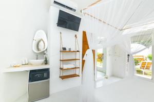 a white bathroom with a sink and a mirror at Igloo Beach Lodge in Manuel Antonio