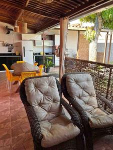2 Korbstühle auf einer Terrasse mit einem Tisch in der Unterkunft Chalé Park Mar, São José e Maragogi in São José da Coroa Grande