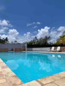 ein großer blauer Swimmingpool mit zwei Liegestühlen in der Unterkunft Chalé Park Mar, São José e Maragogi in São José da Coroa Grande
