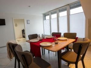 a dining room with a table with a red table cloth at Serviceroom24 - Space in Gladbeck WLAN - Smart-TV - 24-7 Check-in und Küche in Gladbeck