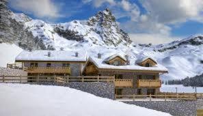 ein schneebedecktes Gebäude mit einem Berg im Hintergrund in der Unterkunft Maison Carrel Elegant 6 in Breuil-Cervinia