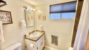 a bathroom with a sink and a toilet and a mirror at Sweet Cabin Home Getaway! in Big Bear City +24 photos