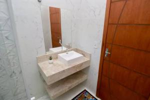 a bathroom with a sink and a mirror at Casa próxima aos pontos turísticos in Foz do Iguaçu