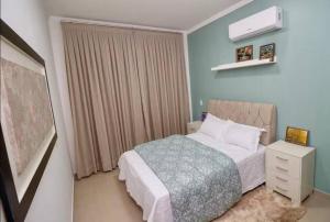 a bedroom with a bed and a dresser and a window at Casa próxima aos pontos turísticos in Foz do Iguaçu
