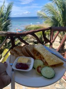 a plate of food on a table with the beach at Kobe's Beachfront Haven in Siquijor