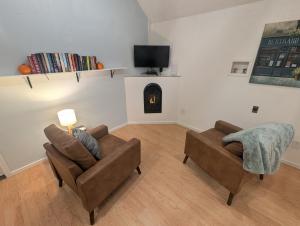 a living room with two couches and a tv at Willamette Cottage in Salem