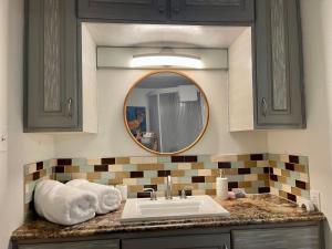 ein Badezimmer mit Waschbecken und Spiegel in der Unterkunft Cozy Condo in Lake Charles + 9 Fotos