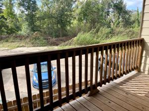 ein Auto, das auf einer Veranda mit Schiene parkt in der Unterkunft Cozy Condo in Lake Charles