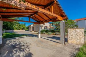 a wooden pergola in front of a building at Family friendly house with a parking space Privlaka, Zadar - 23633 in Privlaka