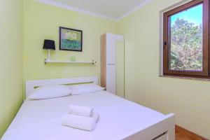 a bedroom with a white bed and a window at Family friendly house with a parking space Privlaka, Zadar - 23633 in Privlaka +6 photos