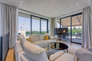 un soggiorno con un divano bianco e una TV di Luxury villa with a swimming pool Savudrija, Umag - 23625 a Crveni Vrh (Monterosso)