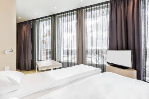 1 Schlafzimmer mit 2 Betten und einem Flachbild-TV in der Unterkunft Sound Garden Hotel Airport in Warschau