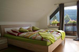 アインルールにあるHaus am Seeの大きな窓のあるベッドのある寝室