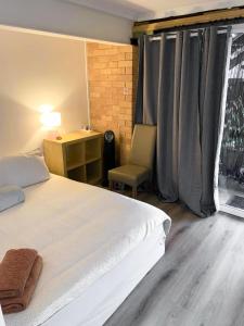 una camera con letto, scrivania e finestra di Sunshine Rooms a Maroochydore