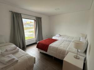 a hotel room with two beds and a window at Haven Patagonia in El Calafate