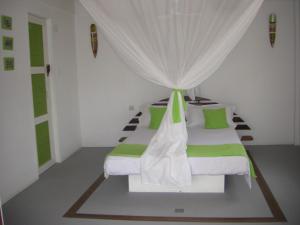 a bedroom with two beds with green and white pillows at Le Jardin de L'isle in Ifaty