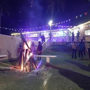 Un groupe de personnes debout autour d'un feu de camp la nuit dans l'établissement Recanto dos Passaros, à Socorro 61 autres photos
