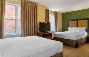 a hotel room with two beds and a flat screen tv at Extended Stay America Suites - Detroit - Novi - Orchard Hill Place in Northville +27 photos