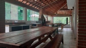 une cuisine avec une table en bois et quelques chaises dans l'établissement Recanto dos Passaros, à Socorro