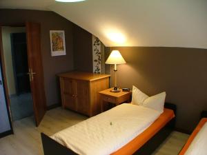 a small bedroom with a bed and a night stand at Hotel garni Pension Zur Lutherstadt in Lutherstadt Eisleben