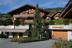 a large house with a wooden garage at Apartment Atlanta - GRIWA RENT AG in Grindelwald