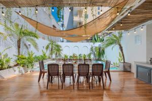 ブンタウにあるOCEAN HOUSE - Đi Bộ 100 Met Ra Biển Bãi Sau Thùy Vânのヤシの木が茂る部屋(テーブル、椅子付)