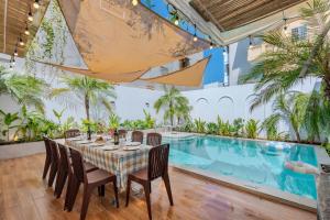 ブンタウにあるOCEAN HOUSE - Đi Bộ 100 Met Ra Biển Bãi Sau Thùy Vânのダイニングルーム(テーブル、椅子付)