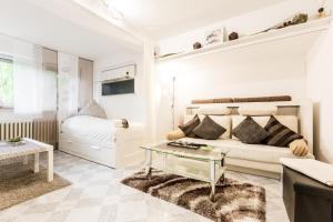 a white bedroom with a bed and a table at Apartments Neuss in Neuss