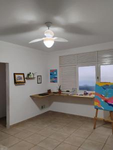 a living room with a ceiling fan and a desk at Projeto FZ Hospedagem in Salvador