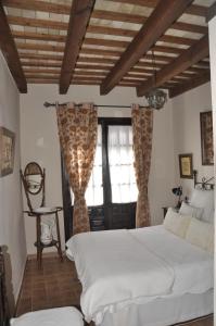 sypialnia z białym łóżkiem i oknem w obiekcie Casa Andrea w mieście Vejer de la Frontera