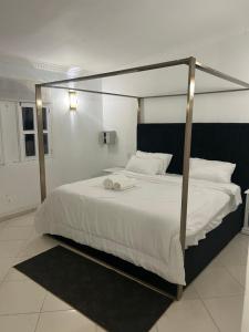 a bedroom with a large bed with a metal canopy at Hannabi Beach Hotel in Boca Chica