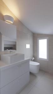 biała łazienka z umywalką i toaletą w obiekcie New Loft by Ossiano Pool Villas, Heating Pool,2 min drive to Haraki Beach & 10 to Lindos w mieście Charaki