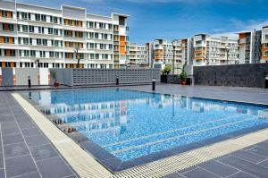 a large swimming pool in front of some buildings at Quin Homestay UUC in Kampong Kayumatang
