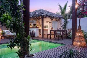 a villa with a swimming pool and a house at Villa Métisse in Jericoacoara