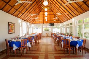 um salão de banquetes com mesas e cadeiras azuis em Sanha Plus Hotel em Santa Marta