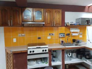 a kitchen with brown cabinets and a white stove top oven at Apartamento Cemandy in Villa de Leyva